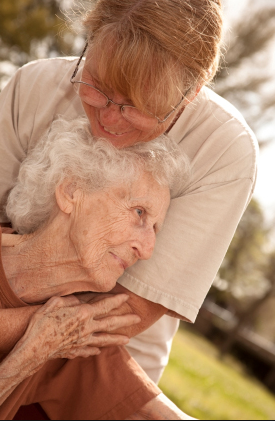 Abrazo entre cuidadora y anciana