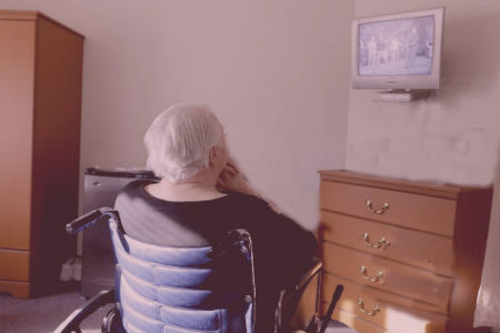 Anciana sentada de espaldas en silla de ruedas